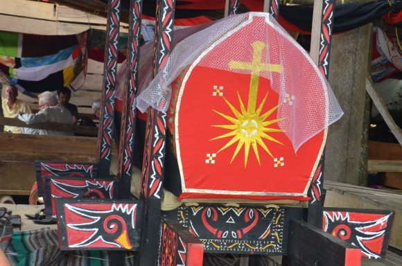 The colorful and carved coffin under the Tongkonan house.